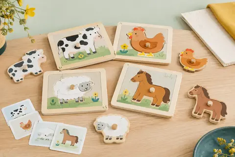 Puzzles en bois à encastrements sur le thème des animaux de la ferme, posés sur du bois clair