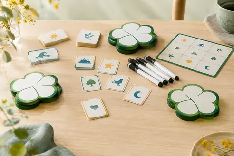 Tablettes vertes en forme de trèfle, cartes et feutres du jeu coopératif So Clover !